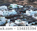 White buildings, town among volcanic black mountains and lava formations in Lanzarote, Canary Islands. 134835394