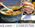 A woman eating warm udon noodles 134835766