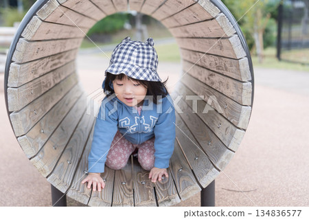 Japanese girl toddler playing on playground equipment in the park 134836577