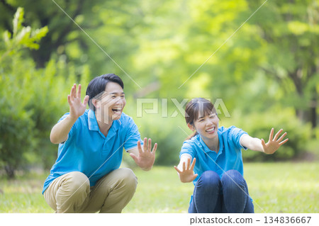 身穿藍色polo衫的男女工作人員正在和孩子們玩耍 134836667