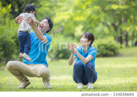 Male and female staff in blue polo shirts playing with children 134836669
