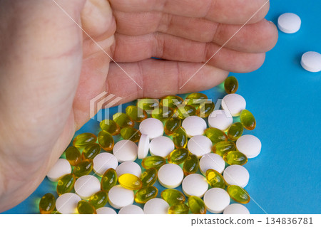 Hand holding assorted vitamin pills 134836781