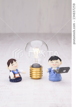 Businessman and office lady dolls and a flashing light bulb 134837259