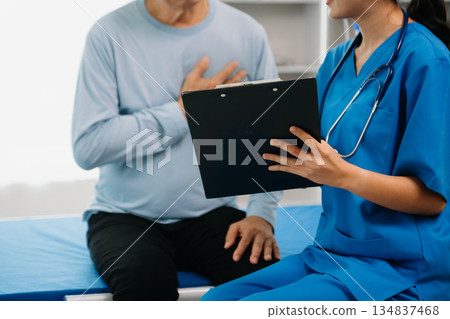 Senior Doctor discussing treatment with male patient talking and laughing sitting on examination bed Senior Doctor discussing treatment with male patient talking and laughing sitting on examination bed 134837468