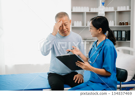Senior Doctor discussing treatment with male patient talking and laughing sitting on examination bed 134837469