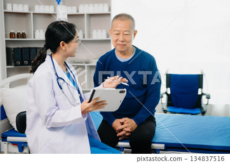 Doctor discussing treatment with Senior male patient talking and laughing sitting on examination bed in clinic or hospital 134837516