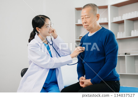 Doctor discussing treatment with Senior male patient talking and laughing sitting on examination bed in clinic or hospital 134837527