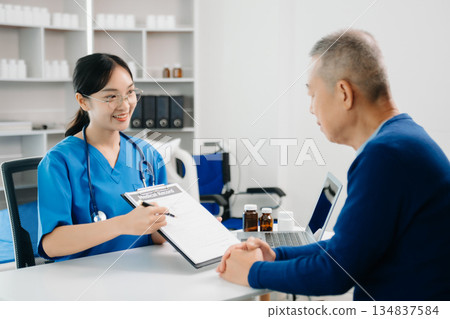 Asia female doctor using clipboard is delivering great news talk discuss results or symptoms with female patient in clinic 134837584