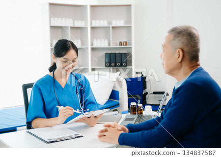 Asia female doctor using clipboard is delivering great news talk discuss results or symptoms with female patient in clinic Asia female doctor using clipboard is delivering great news talk discuss results or symptoms with female patient in clinic 134837587