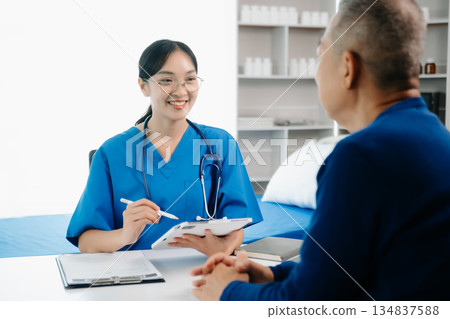 Asia female doctor using clipboard is delivering great news talk discuss results or symptoms with female patient in clinic Asia female doctor using clipboard is delivering great news talk discuss results or symptoms with female patient in clinic 134837588