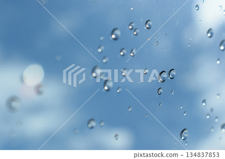 water drop on mirror with blue sky and white cloud background 134837853