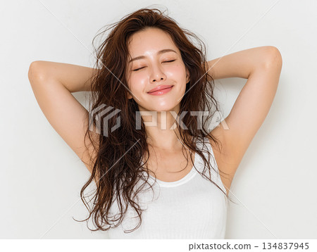 一位三十多歲的日本女性的美麗肖像，她面帶微笑，雙眼緊閉。白色背景。 134837945