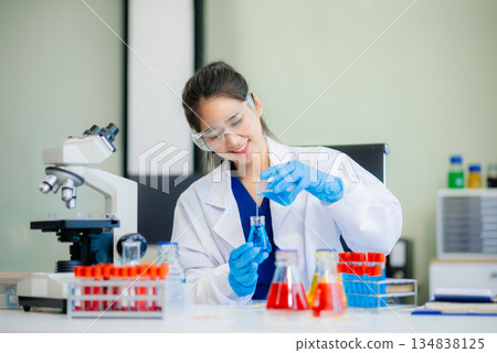 Discover a dedicated scientist conducting laboratory research, using pipettes, microscopes, and lab equipment. 134838125