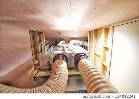Construction of a new house with a large air conditioning unit in the attic Construction of a new house with a large air conditioning unit in the attic 134838241