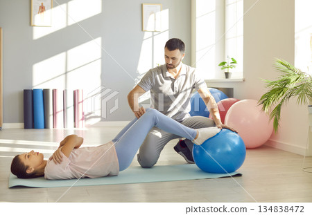 Caucasian Woman Fitness Exercise Using Ball With Personal Trainer Caucasian Woman Fitness Exercise Using Ball With Personal Trainer 134838472