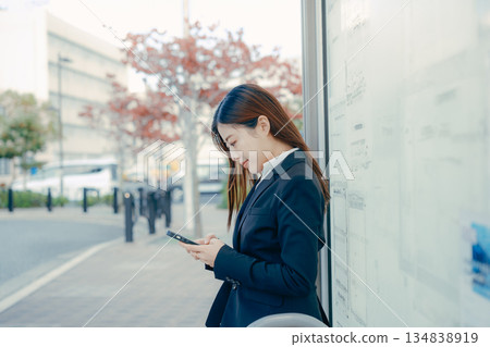 一名日本女大學生在公車站思考著找工作的事。 一名日本女大學生在公車站思考著找工作的事。 134838919
