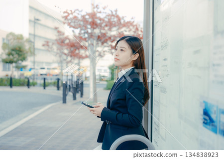 一名日本女大學生在公車站思考著找工作的事。 一名日本女大學生在公車站思考著找工作的事。 134838923
