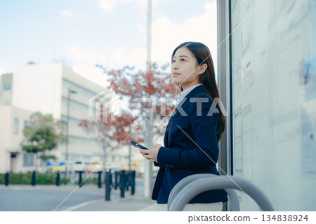 一名日本女大學生在公車站思考著找工作的事。 一名日本女大學生在公車站思考著找工作的事。 134838924