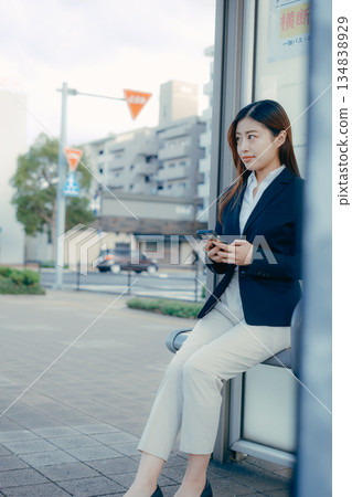 一名日本女大學生在公車站思考著找工作的事。 一名日本女大學生在公車站思考著找工作的事。 134838929