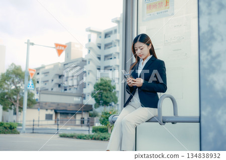 一名日本女大學生在公車站思考著找工作的事。 一名日本女大學生在公車站思考著找工作的事。 134838932