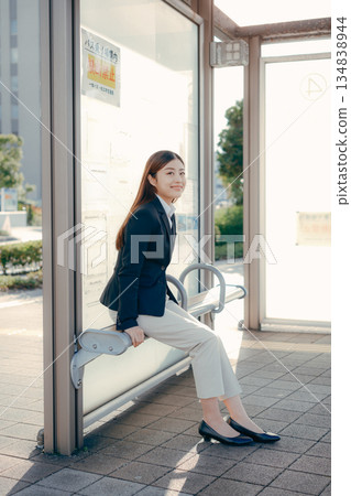 Japanese female university student thinking about job hunting at a bus stop Japanese female university student thinking about job hunting at a bus stop 134838944