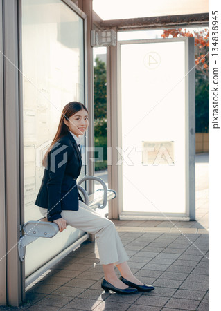 Japanese female university student thinking about job hunting at a bus stop Japanese female university student thinking about job hunting at a bus stop 134838945