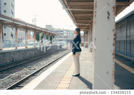一名日本女大學生站在車站月台上 一名日本女大學生站在車站月台上 134839153