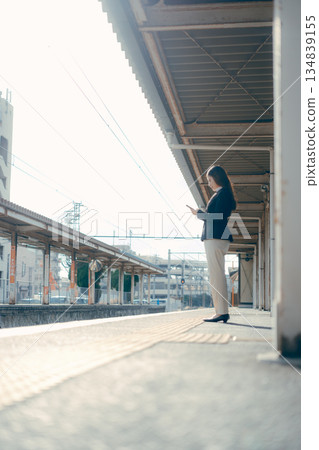 一名日本女大學生站在車站月台上 一名日本女大學生站在車站月台上 134839155