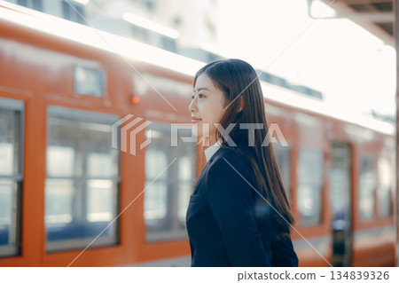 Japanese female university student waiting for a train on the station platform Japanese female university student waiting for a train on the station platform 134839326