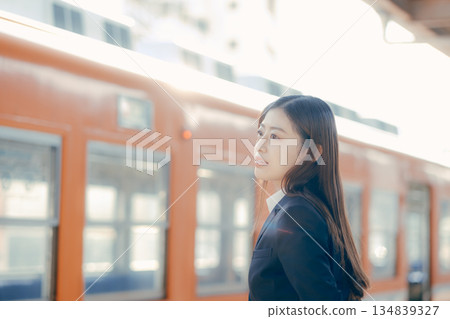 Japanese female university student waiting for a train on the station platform Japanese female university student waiting for a train on the station platform 134839327