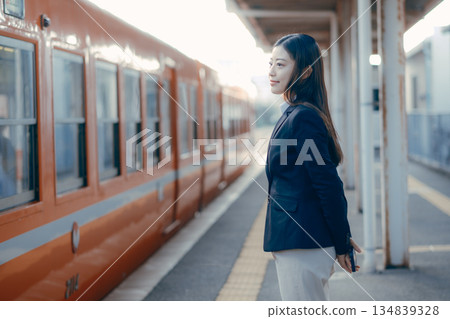 Japanese female university student waiting for a train on the station platform Japanese female university student waiting for a train on the station platform 134839328