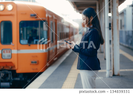Japanese female university student waiting for a train on the station platform Japanese female university student waiting for a train on the station platform 134839331