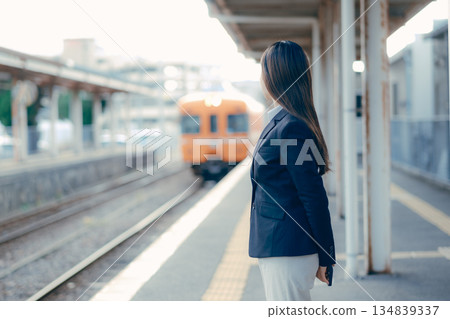 Japanese female university student waiting for a train on the station platform Japanese female university student waiting for a train on the station platform 134839337