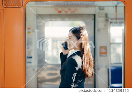 一名日本女大學生正在用智慧型手機通話 一名日本女大學生正在用智慧型手機通話 134839353
