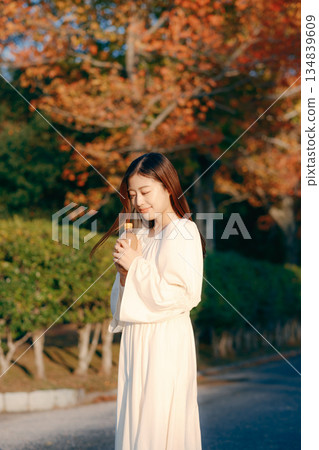 Japanese woman drinking tea in the autumn park Japanese woman drinking tea in the autumn park 134839609