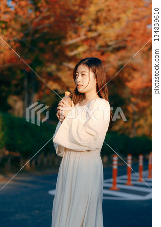 Japanese woman drinking tea in the autumn park 134839610