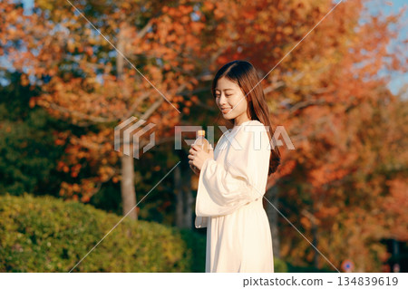 秋日公園裡，一位日本女子正在喝茶 134839619