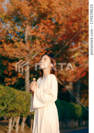 秋日公園裡,一位日本女子正在喝茶 秋日公園裡,一位日本女子正在喝茶 134839620