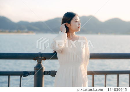 A Japanese woman standing on a levee with the sea in the background A Japanese woman standing on a levee with the sea in the background 134839645