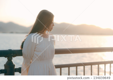 A Japanese woman standing on a levee with the sea in the background A Japanese woman standing on a levee with the sea in the background 134839649