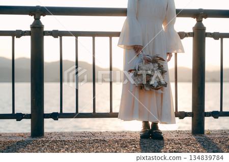 A Japanese woman standing with dried flowers in the background of the sea A Japanese woman standing with dried flowers in the background of the sea 134839784