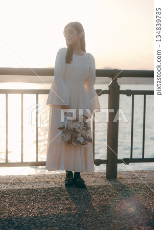 A Japanese woman standing with dried flowers in the background of the sea A Japanese woman standing with dried flowers in the background of the sea 134839785