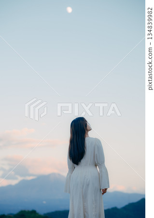 一位日本女子背對著鏡頭，站在大自然中，仰望著天空。 134839982