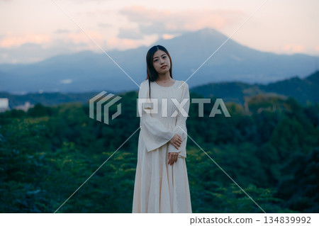 一位日本女子背對著鏡頭，站在大自然中，仰望著天空。 134839992