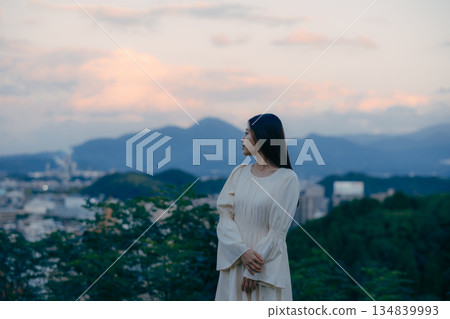 一位日本女子背對著鏡頭,站在大自然中,仰望著天空。 一位日本女子背對著鏡頭,站在大自然中,仰望著天空。 134839993
