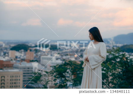 A Japanese woman standing with the cityscape in the background A Japanese woman standing with the cityscape in the background 134840111