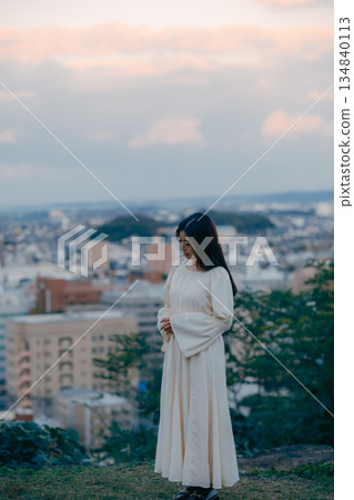 A Japanese woman standing with the cityscape in the background 134840113