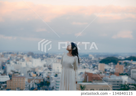 A Japanese woman standing with the cityscape in the background 134840115