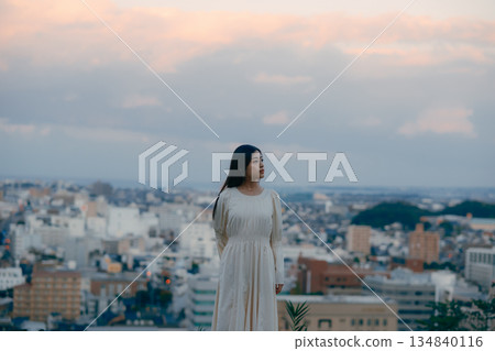 A Japanese woman standing with the cityscape in the background A Japanese woman standing with the cityscape in the background 134840116