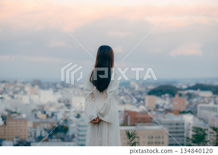 A Japanese woman standing with the cityscape in the background 134840120